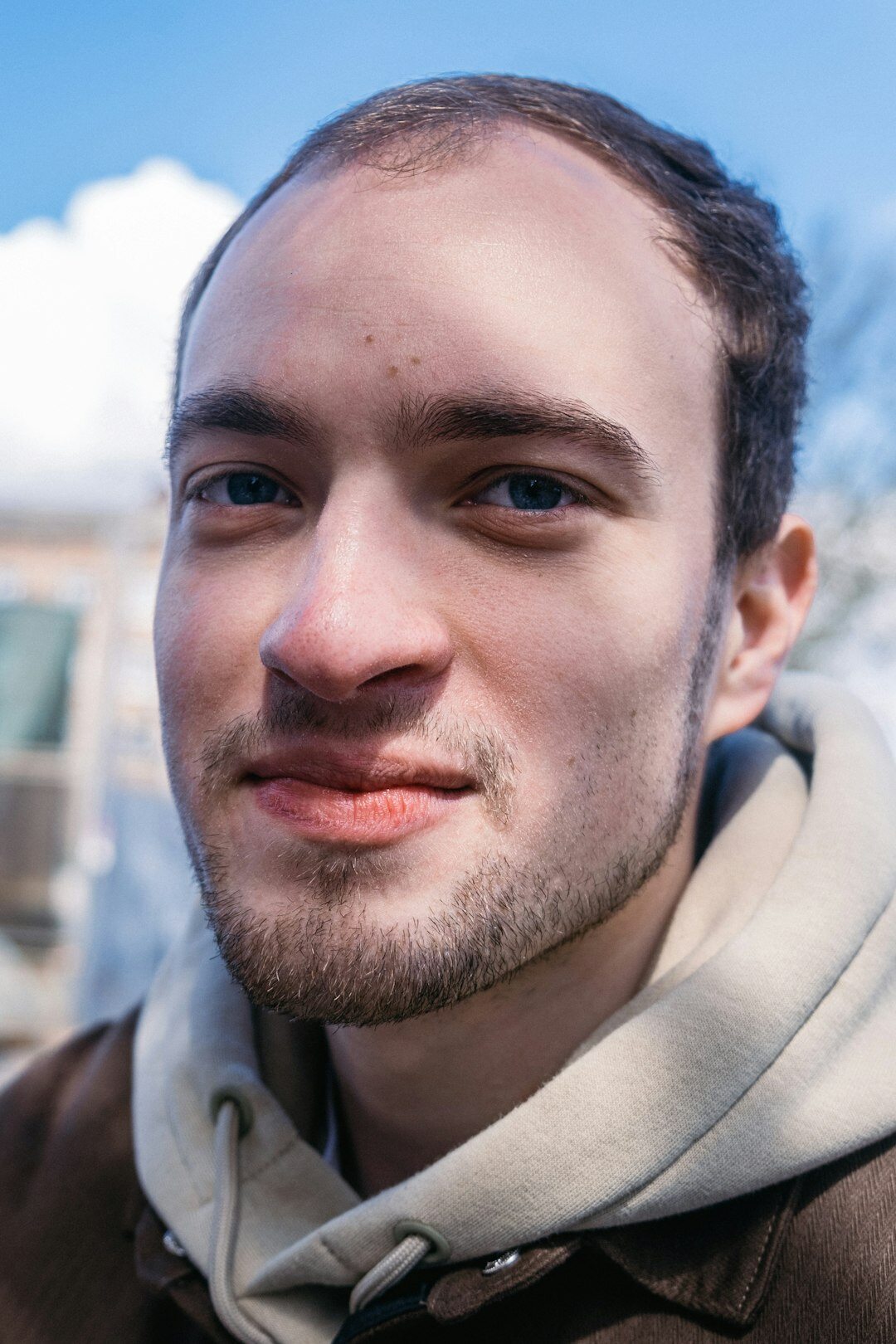 Portrait of a young man with a short beard smiling
