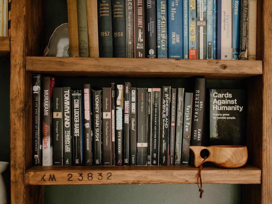 Stack of old mystery novels on a wooden shelf